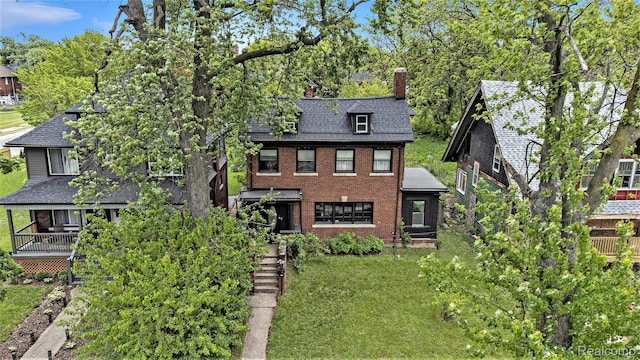 2223 S La Salle Gdns, Detroit, MI 48206 - view of front of house featuring a chimney, a front lawn, brick siding, and roof with shingles