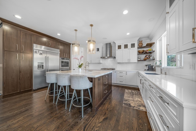 1655 Dorchester Rd, Birmingham, MI 48009 - kitchen featuring stainless steel appliances, wall chimney exhaust hood, a sink, a breakfast bar, and open shelves