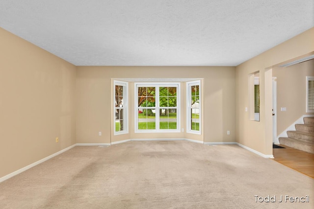 11081 Timberline Dr, Allendale, MI 49401 - carpeted spare room with baseboards, stairway, and a textured ceiling