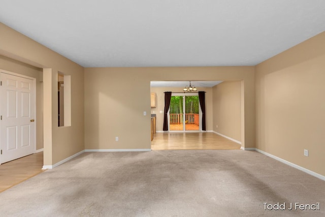 11081 Timberline Dr, Allendale, MI 49401 - unfurnished room featuring light carpet, a chandelier, and baseboards