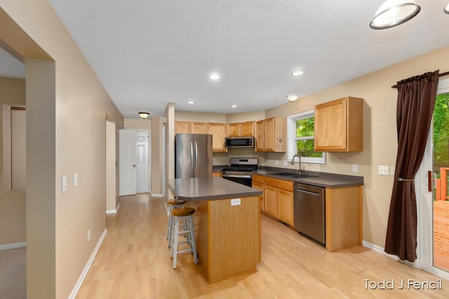 11081 Timberline Dr, Allendale, MI 49401 - kitchen with stainless steel appliances, a sink, dark countertops, light wood-style flooring, and recessed lighting