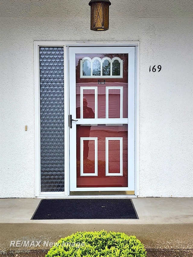 9135 Greenway Blvd, Saginaw, MI 48609 - doorway to property featuring stucco siding