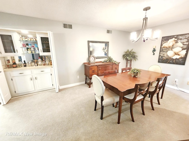 9135 Greenway Blvd, Saginaw, MI 48609 - dining area with a dry bar, light colored carpet, a chandelier, and baseboards