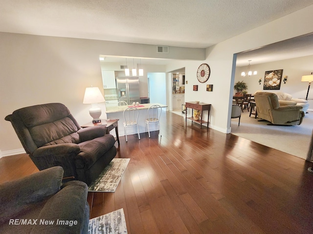 9135 Greenway Blvd, Saginaw, MI 48609 - living area with a chandelier, dark wood-style flooring, a textured ceiling, and baseboards