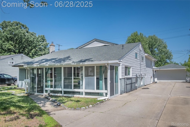 36426 Weideman St, Clinton Township, MI 48035 - view of front facade with a sunroom, a shingled roof, a chimney, and an outdoor structure