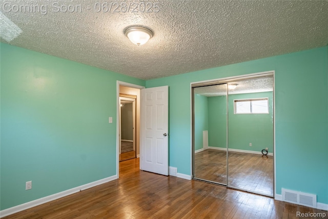 36426 Weideman St, Clinton Township, MI 48035 - unfurnished bedroom featuring a textured ceiling, a closet, and wood-type flooring