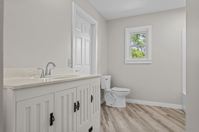 7060 Dobson Rd, Jonesville, MI 49250 - full bathroom featuring baseboards, toilet, vanity, and wood finished floors