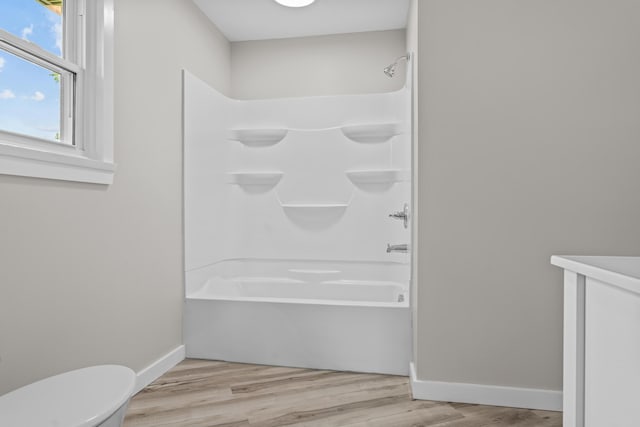 7060 Dobson Rd, Jonesville, MI 49250 - full bathroom with shower / bathtub combination, toilet, wood finished floors, and baseboards