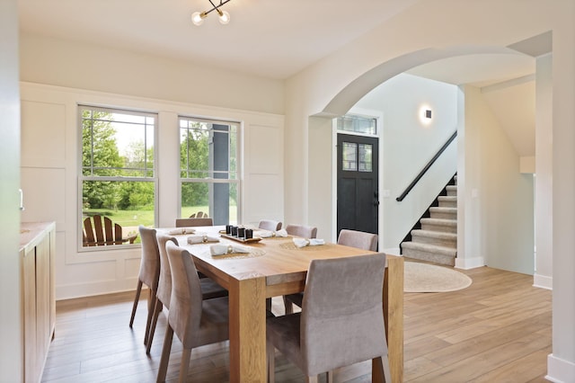 8460 Woodridge Dr, Davison, MI 48423 - dining space with stairway, plenty of natural light, arched walkways, and light wood finished floors