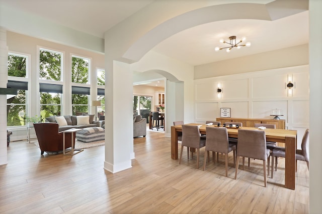 8460 Woodridge Dr, Davison, MI 48423 - dining space with arched walkways, a chandelier, and light wood-style floors
