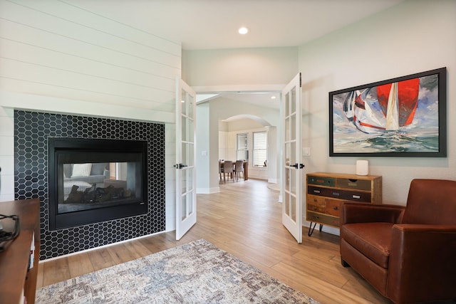 8460 Woodridge Dr, Davison, MI 48423 - living area with arched walkways, wood finished floors, french doors, a fireplace, and recessed lighting