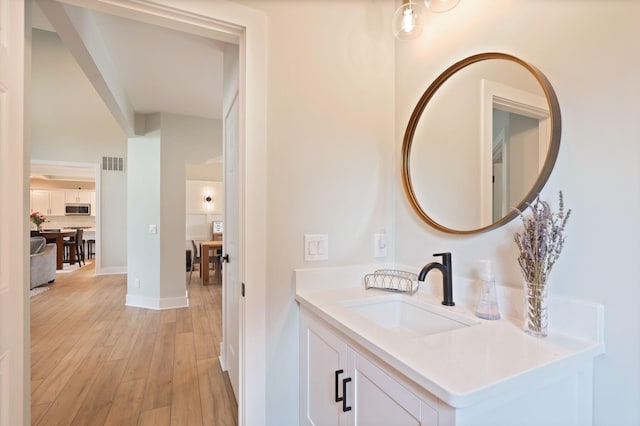 8460 Woodridge Dr, Davison, MI 48423 - bathroom featuring wood finished floors and vanity