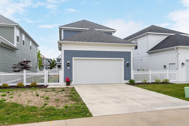 245 Cavelier Ave, Saint Joseph, MI 49085 - view of front of property with roof with shingles, a garage, concrete driveway, and board and batten siding
