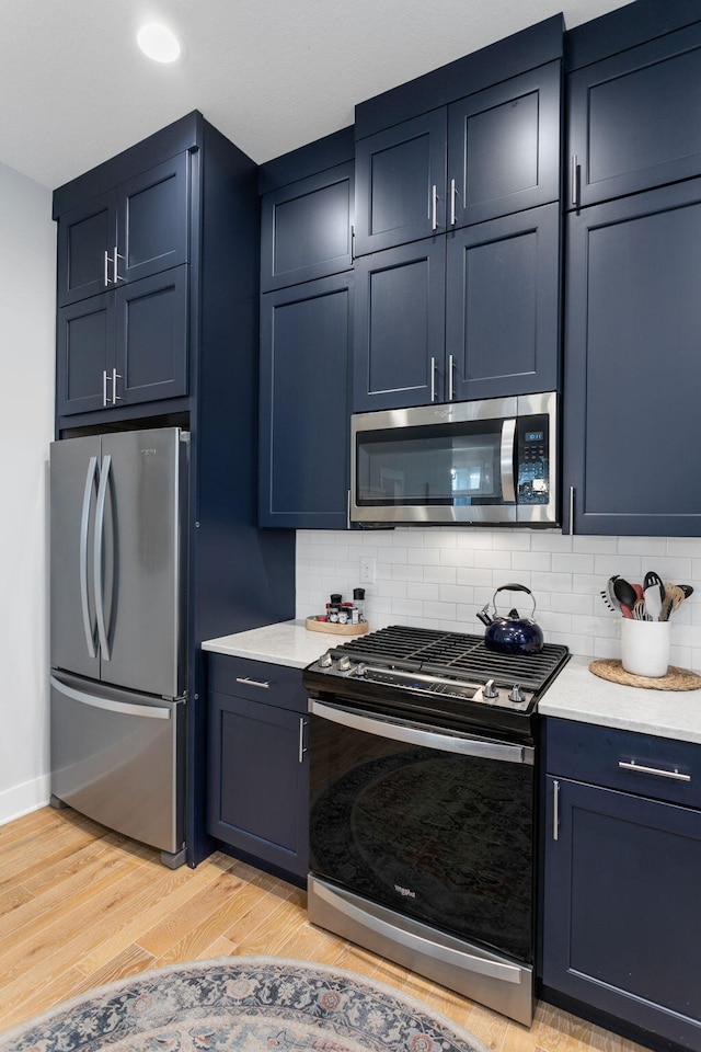 245 Cavelier Ave, Saint Joseph, MI 49085 - kitchen featuring stainless steel appliances, decorative backsplash, light wood finished floors, and baseboards