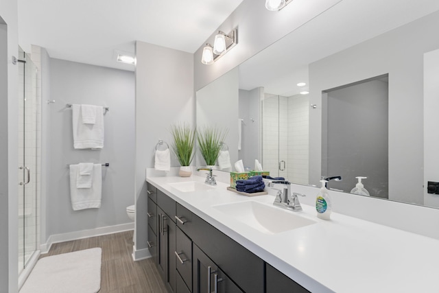 245 Cavelier Ave, Saint Joseph, MI 49085 - bathroom featuring double vanity, a shower stall, toilet, and wood finished floors