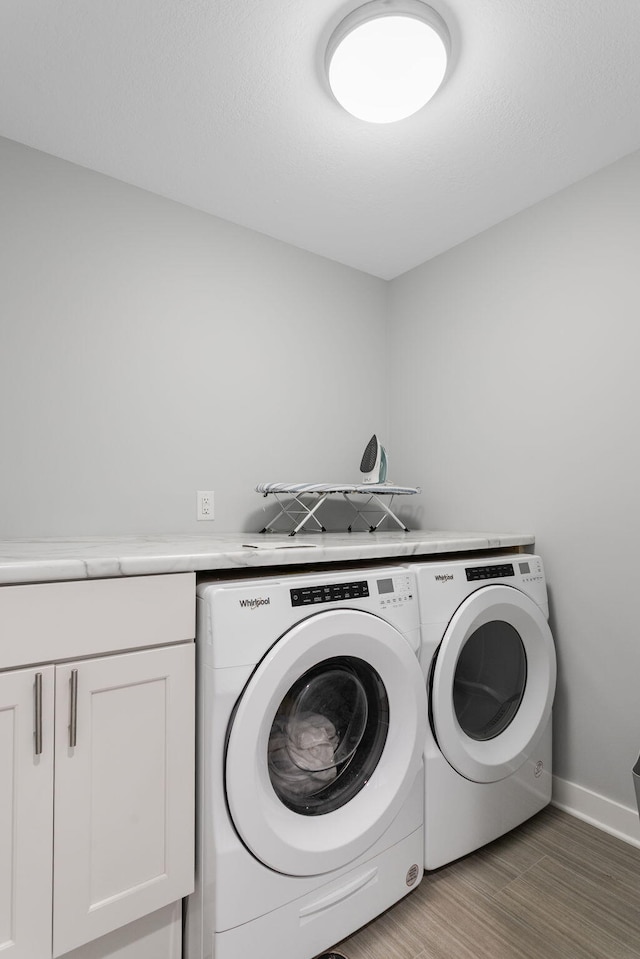 245 Cavelier Ave, Saint Joseph, MI 49085 - laundry area featuring separate washer and dryer, baseboards, wood finished floors, and cabinet space
