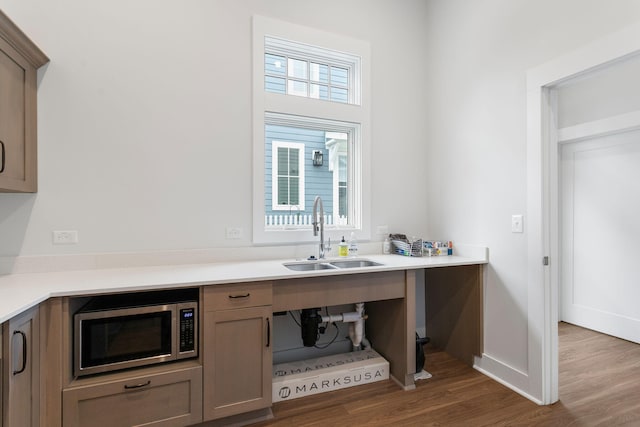 245 Cavelier Ave, Saint Joseph, MI 49085 - kitchen featuring a sink, stainless steel microwave, dark wood-type flooring, light countertops, and baseboards