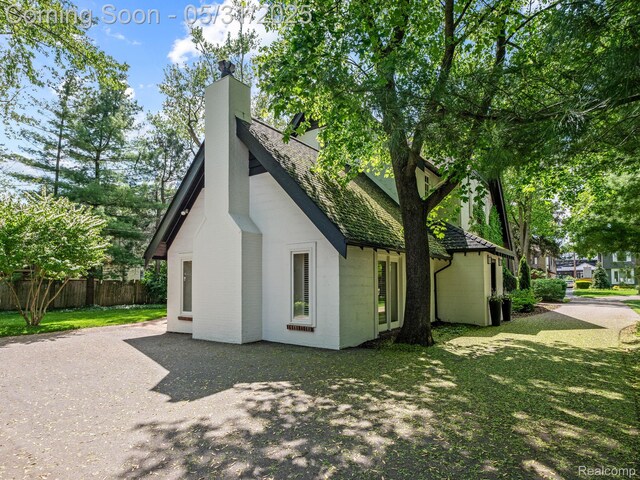 822 Suffield Ave, Birmingham, MI 48009 - view of property exterior featuring a chimney, a shingled roof, and a patio area
