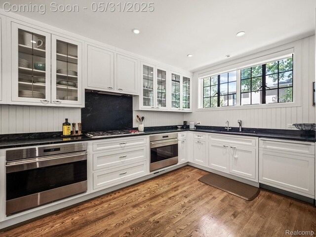 822 Suffield Ave, Birmingham, MI 48009 - kitchen with appliances with stainless steel finishes, a sink, white cabinets, wood finished floors, and dark countertops