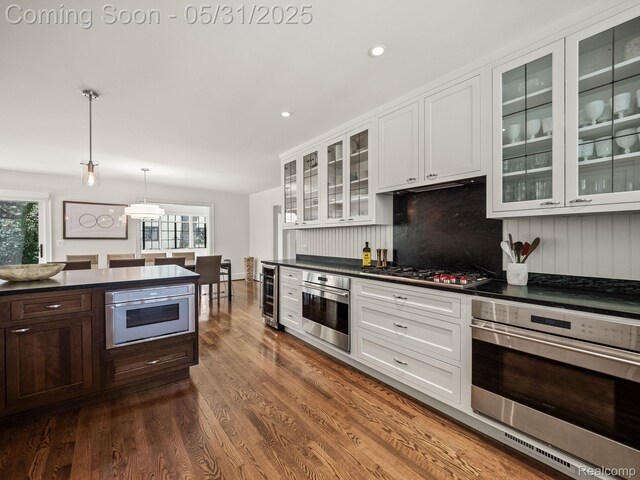 822 Suffield Ave, Birmingham, MI 48009 - kitchen featuring stainless steel appliances, dark countertops, beverage cooler, dark wood-style flooring, and white cabinetry