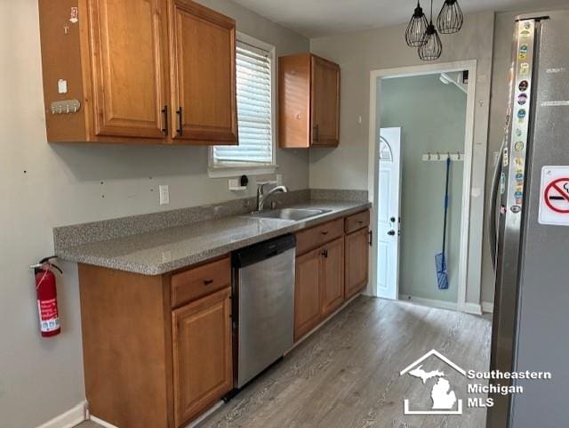 13535 Netherwood St, Southgate, MI 48195 - kitchen with stainless steel appliances, a sink, light wood-style floors, light countertops, and baseboards