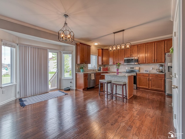691 Foxworth St, Dundee, MI 48131 - kitchen with stainless steel appliances, brown cabinetry, a sink, a kitchen island, and a chandelier