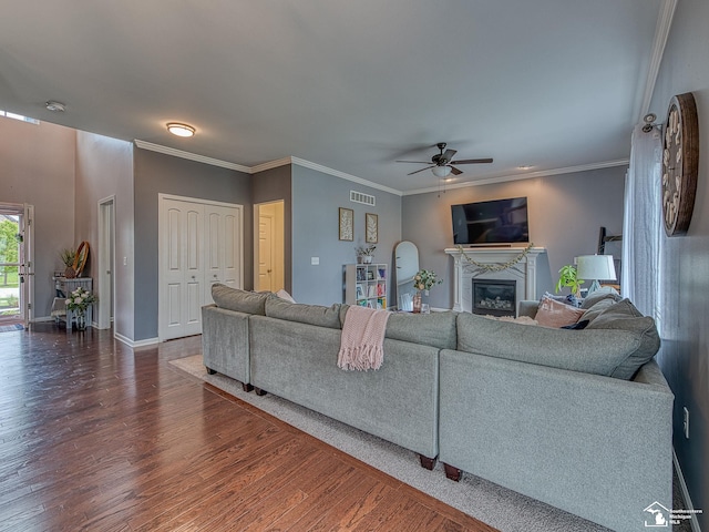 691 Foxworth St, Dundee, MI 48131 - living area featuring dark wood-style floors, a ceiling fan, a fireplace, baseboards, and crown molding