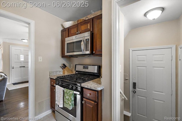 2111 Ellwood Ave, Berkley, MI 48072 - kitchen featuring stainless steel appliances, wood finished floors, and light stone counters