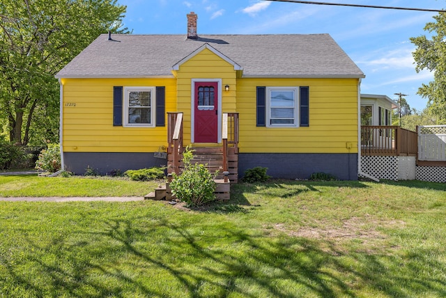 17270 Taft Rd, Spring Lake, MI 49456 - view of front facade with roof with shingles, a front yard, a chimney, and a wooden deck