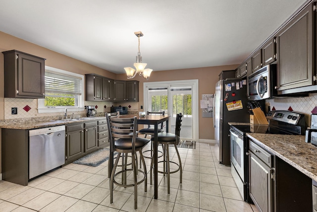 17270 Taft Rd, Spring Lake, MI 49456 - kitchen with stainless steel appliances, a sink, a chandelier, and backsplash