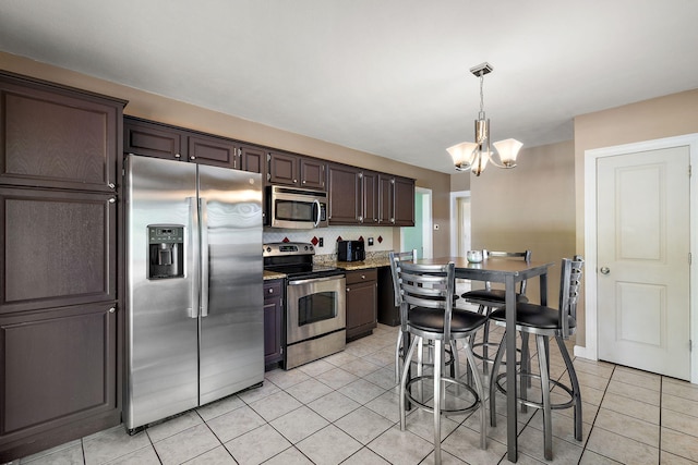 17270 Taft Rd, Spring Lake, MI 49456 - kitchen featuring stainless steel appliances, light tile patterned flooring, a chandelier, dark brown cabinets, and hanging light fixtures