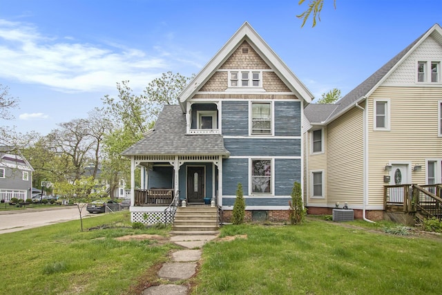 1122 Main St, Saint Joseph, MI 49085 - victorian-style house with covered porch, central AC unit, a front yard, and a shingled roof