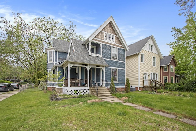 1122 Main St, Saint Joseph, MI 49085 - victorian home with covered porch, roof with shingles, and a front yard