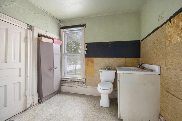 1122 Main St, Saint Joseph, MI 49085 - half bath with tile walls, toilet, vanity, a wainscoted wall, and ornamental molding