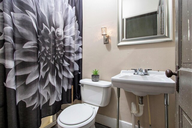 1122 Main St, Saint Joseph, MI 49085 - bathroom with toilet, curtained shower, and baseboards