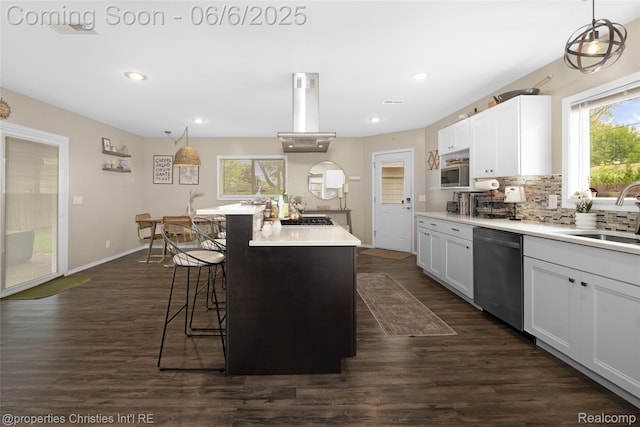 34143 Zimmer Dr, Sterling Heights, MI 48310 - kitchen with appliances with stainless steel finishes, a sink, island exhaust hood, a breakfast bar area, and light countertops