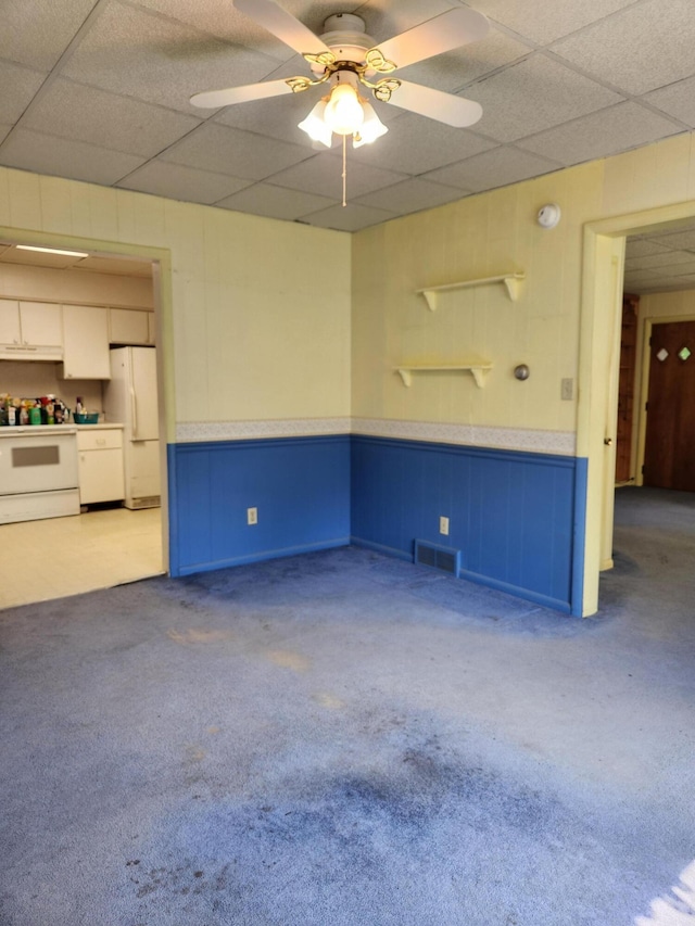 8324 Hagar Shore Rd, Watervliet, MI 49098 - unfurnished room with carpet, a paneled ceiling, ceiling fan, and a wainscoted wall