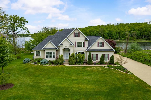 4132 Winding Way, Kalamazoo, MI 49004 - traditional-style home with a front lawn, roof with shingles, a water view, and driveway