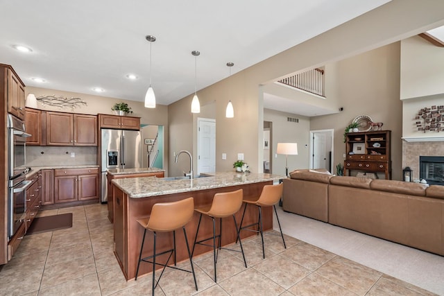 4132 Winding Way, Kalamazoo, MI 49004 - kitchen with a breakfast bar area, light tile patterned flooring, a sink, open floor plan, and light stone countertops