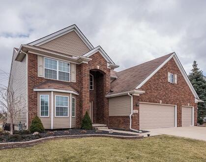 449 Corinth Cir, Dundee, MI 48131 - traditional-style house with brick siding, concrete driveway, and a front lawn