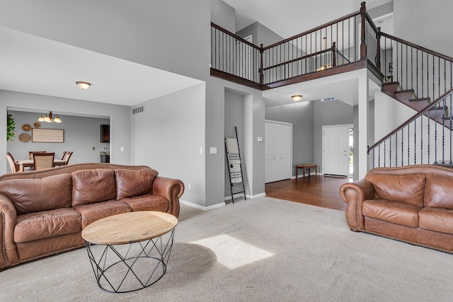 449 Corinth Cir, Dundee, MI 48131 - carpeted living room featuring stairway, a chandelier, a towering ceiling, and baseboards