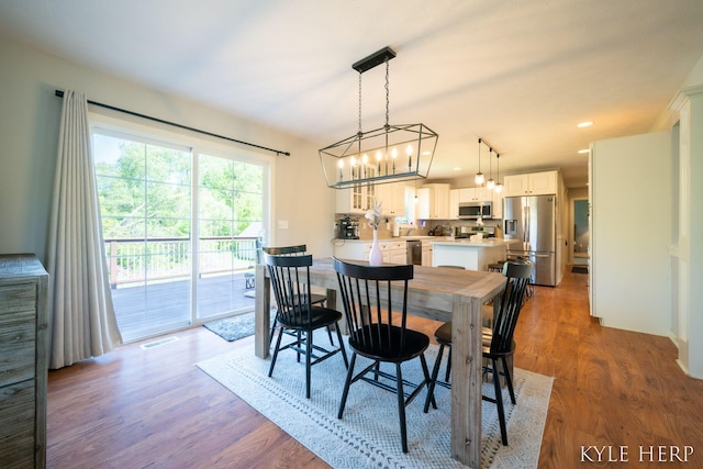 8718 Little Bend Ct, Middleville, MI 49333 - dining space with a chandelier, wood finished floors, and recessed lighting