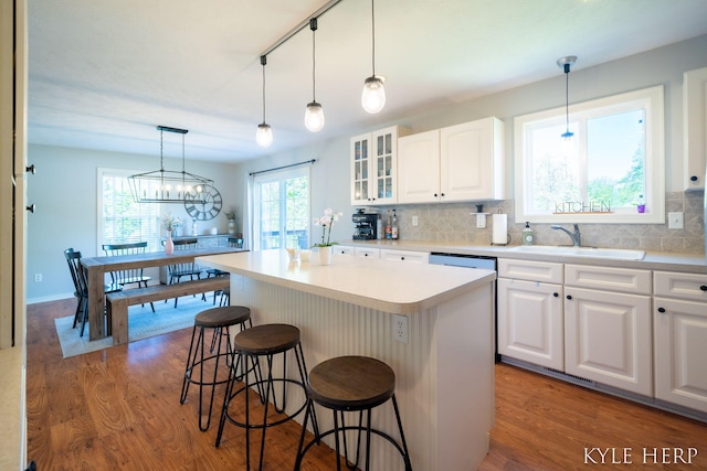 8718 Little Bend Ct, Middleville, MI 49333 - kitchen with a sink, a kitchen breakfast bar, wood finished floors, and white cabinetry
