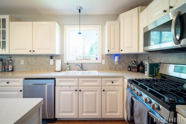 8718 Little Bend Ct, Middleville, MI 49333 - kitchen with appliances with stainless steel finishes, a sink, white cabinets, and decorative backsplash
