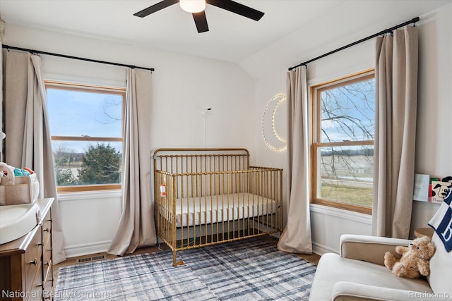 2020 Nicholson Rd, Fowlerville, MI 48836 - bedroom with a nursery area, baseboards, wood finished floors, lofted ceiling, and ceiling fan