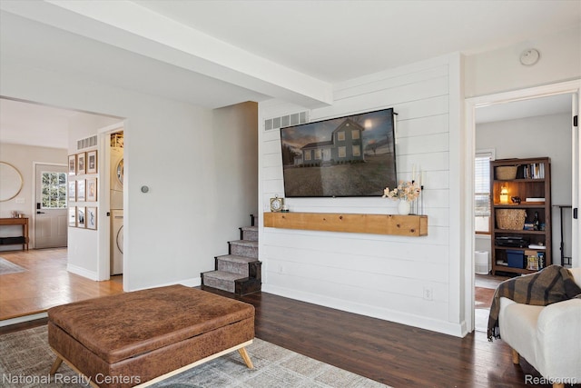 2020 Nicholson Rd, Fowlerville, MI 48836 - living area with stacked washer and clothes dryer, wood finished floors, baseboards, and stairway