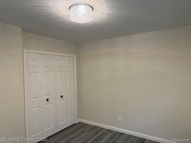 29054 Burning Tree Ln, Romulus, MI 48174 - unfurnished bedroom featuring baseboards, dark wood-style flooring, and a closet