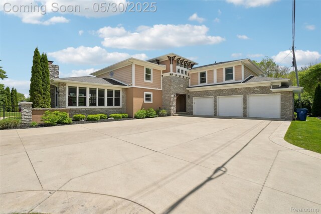 13525 Torrey Rd, Fenton, MI 48430 - view of front of property with driveway, stone siding, a garage, and a chimney