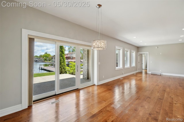 13525 Torrey Rd, Fenton, MI 48430 - spare room featuring baseboards, a chandelier, wood finished floors, recessed lighting, and a water view