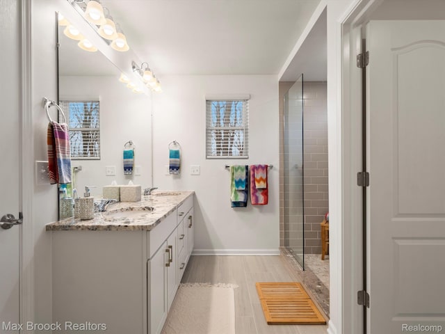 764 Hummingbird Dr, Rochester, MI 48307 - bathroom with double vanity, baseboards, and a shower with door